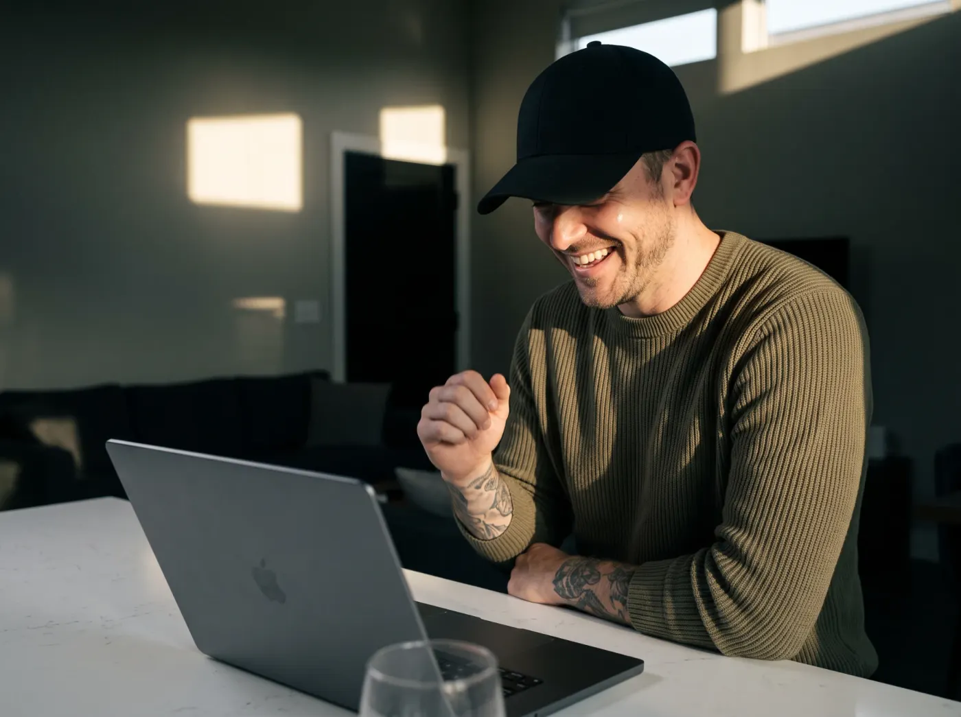 Homem comemorando diante do notebook ao ver uma venda entrar